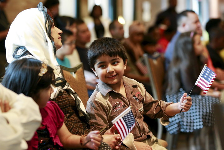 Fiza Kamran, whose parents immigrated from Pakistan, waves a flag during a citizenship ceremony at the Bronx Zoo in New York May 26, 2015. Shannon Stapleton / Reuters