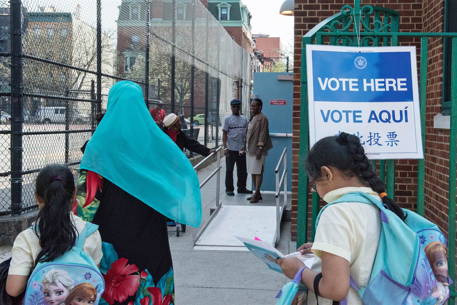 A woman with a Muslim headscarf walks past a voting sign on April 19 in Brooklyn, New York. Stephanie Keith / Getty Images